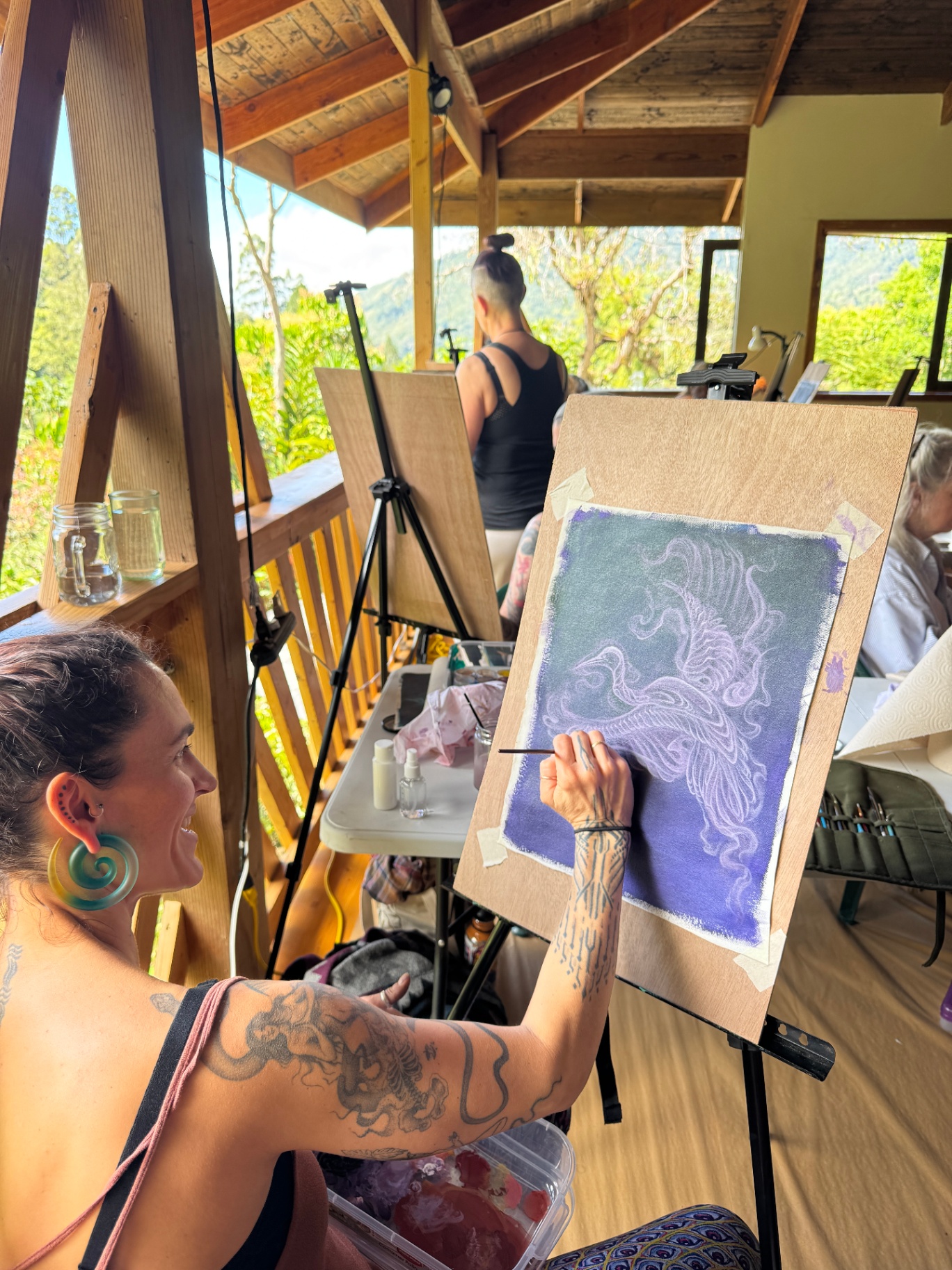 Artist painting a violet visionary bird at the easel